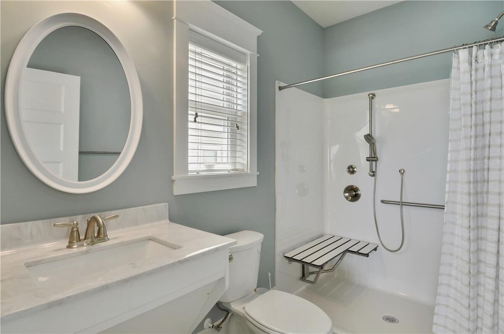 Photo of a mid-sized beach style 3/4 bathroom in Other with white cabinets, an alcove shower, a one-piece toilet, white tile, grey walls, dark hardwood floors, an undermount sink and quartzite benchtops.