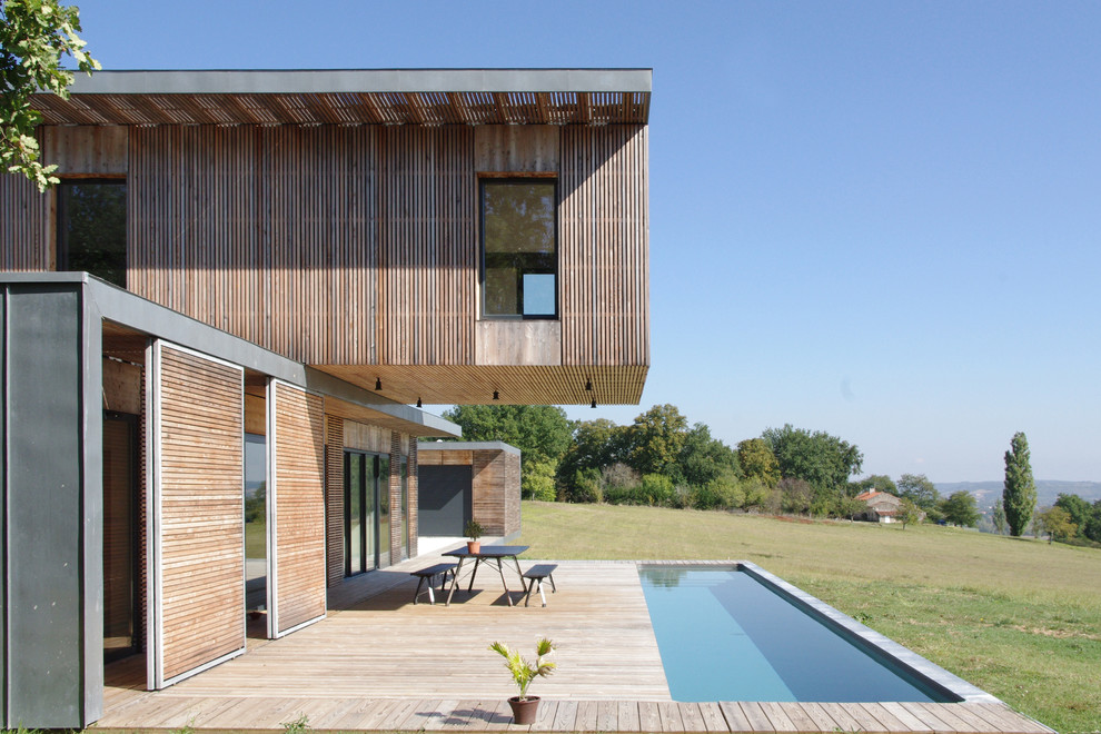 This is an example of a mid-sized contemporary backyard rectangular lap pool in Bordeaux with decking.
