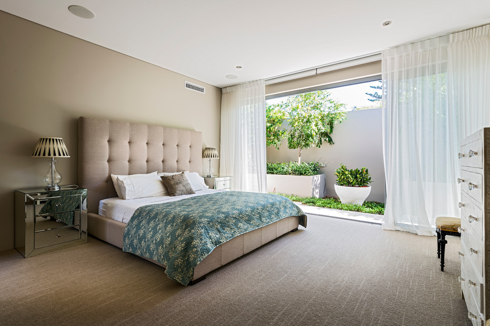 This is an example of a large contemporary bedroom in Perth with beige walls and carpet.