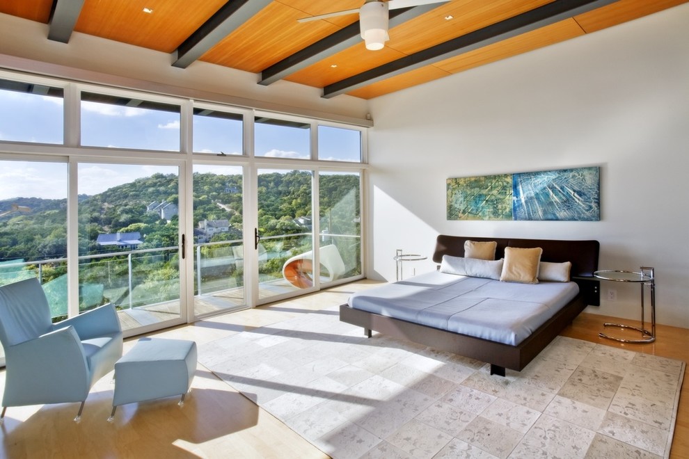 Mid-sized contemporary master bedroom in Austin with white walls, medium hardwood floors, no fireplace and brown floor.