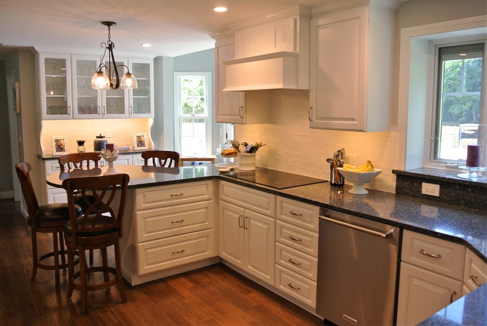 Eat-in kitchen - transitional light wood floor eat-in kitchen idea in Boston with an undermount sink, raised-panel cabinets, white cabinets, granite countertops, white backsplash, subway tile backsplash and stainless steel appliances
