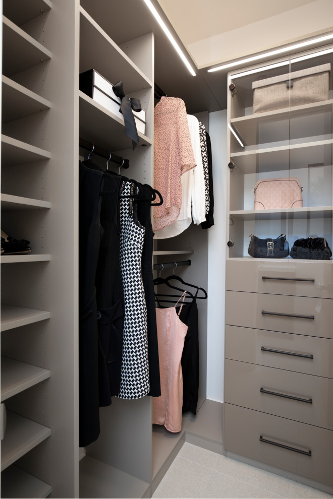 Ejemplo de armario vestidor de mujer minimalista de tamaño medio con armarios abiertos y puertas de armario beige