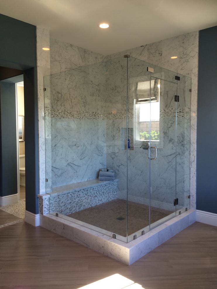Expansive beach style master bathroom in San Diego with marble benchtops, a corner shower, a two-piece toilet, white tile, mosaic tile, blue walls and limestone floors.