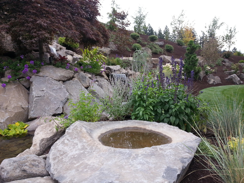 Inspiration for a mid-sized traditional backyard formal garden in Portland with a water feature and natural stone pavers.