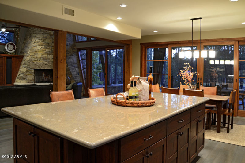 Inspiration for a mid-sized rustic l-shaped light wood floor and gray floor open concept kitchen remodel with shaker cabinets, medium tone wood cabinets, marble countertops and an island
