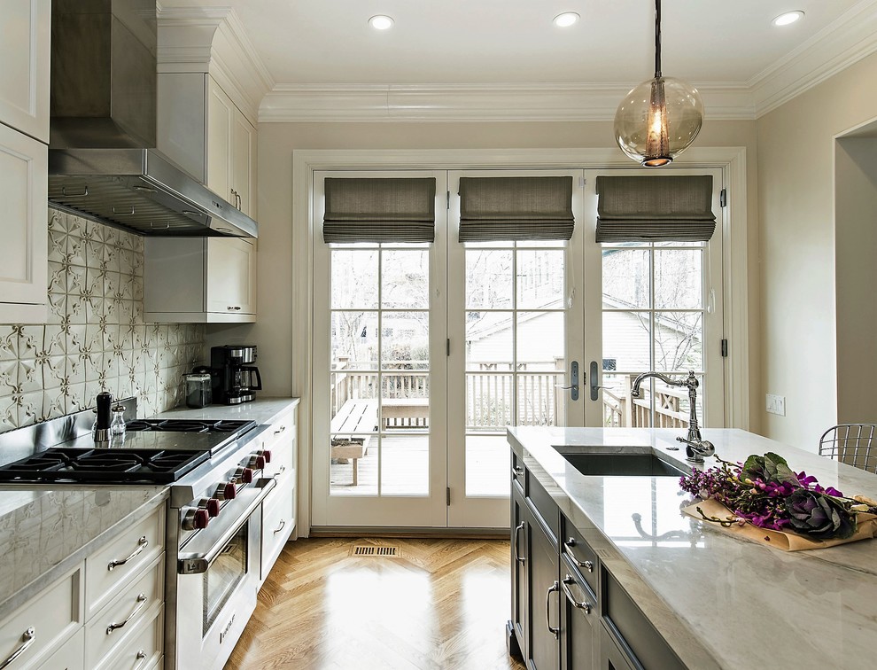 Inspiration for a mid-sized transitional l-shaped medium tone wood floor open concept kitchen remodel in Chicago with an undermount sink, flat-panel cabinets, white cabinets, granite countertops, beige backsplash, stainless steel appliances, an island and mosaic tile backsplash
