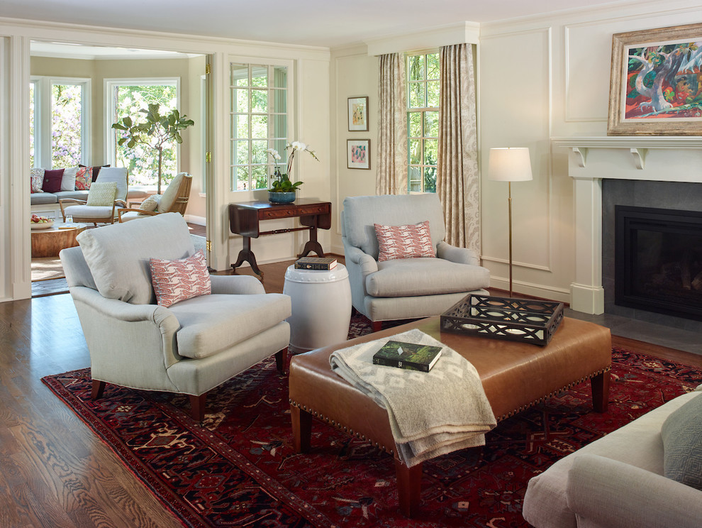 Large traditional enclosed living room in Portland with white walls, dark hardwood floors, a standard fireplace, a wood fireplace surround and brown floor.