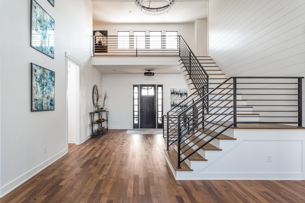 Large country foyer in Indianapolis with white walls, medium hardwood floors, a single front door, a black front door and multi-coloured floor.