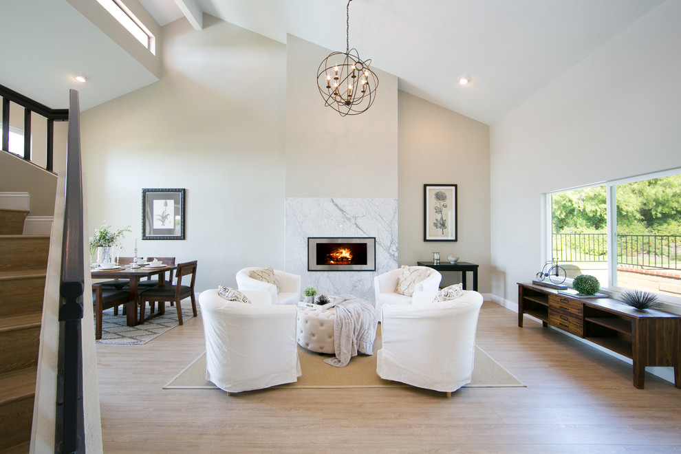 Inspiration for a transitional formal open concept living room in Orange County with white walls, light hardwood floors, a ribbon fireplace and a metal fireplace surround.