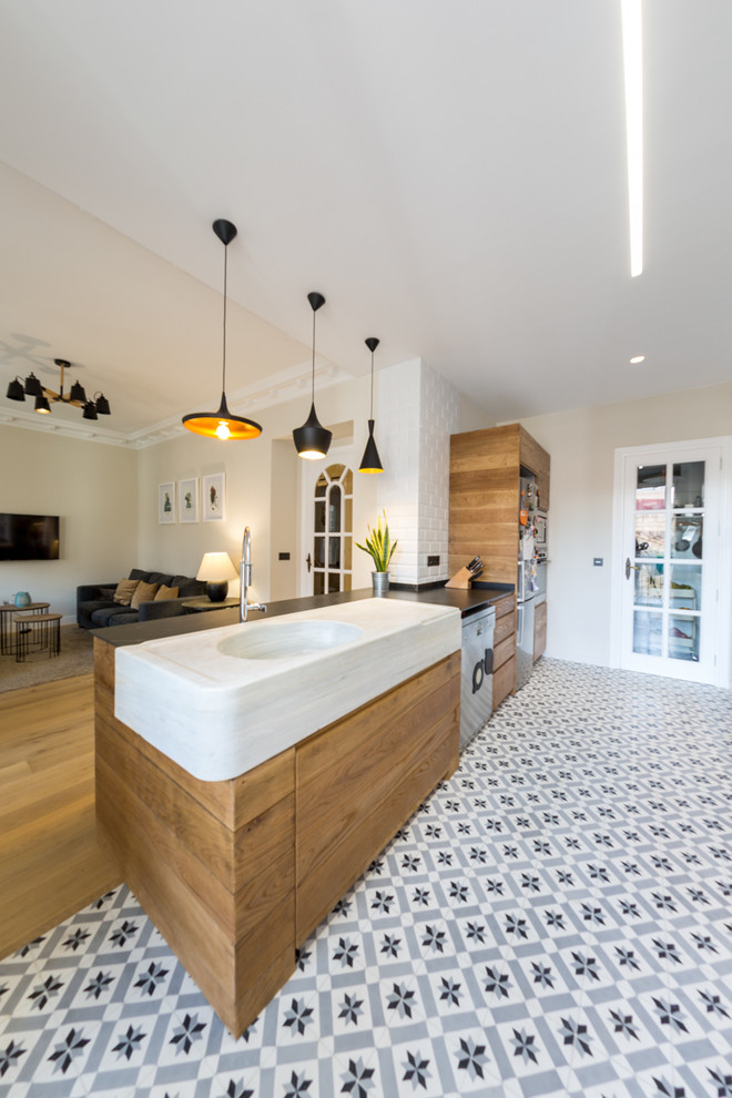 This is an example of a mid-sized contemporary galley open plan kitchen in Alicante-Costa Blanca with flat-panel cabinets, medium wood cabinets, white splashback, subway tile splashback, a peninsula, a farmhouse sink, marble benchtops, stainless steel appliances, terra-cotta floors and blue floor.