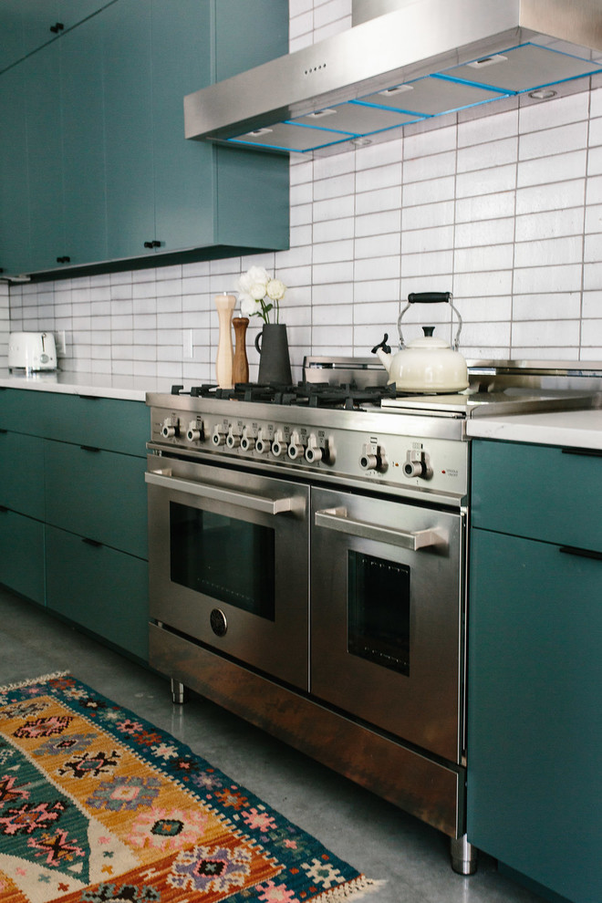 Inspiration for a mid-sized contemporary l-shaped eat-in kitchen in Austin with a farmhouse sink, flat-panel cabinets, green cabinets, quartzite benchtops, white splashback, brick splashback, stainless steel appliances, concrete floors, with island, grey floor and white benchtop.