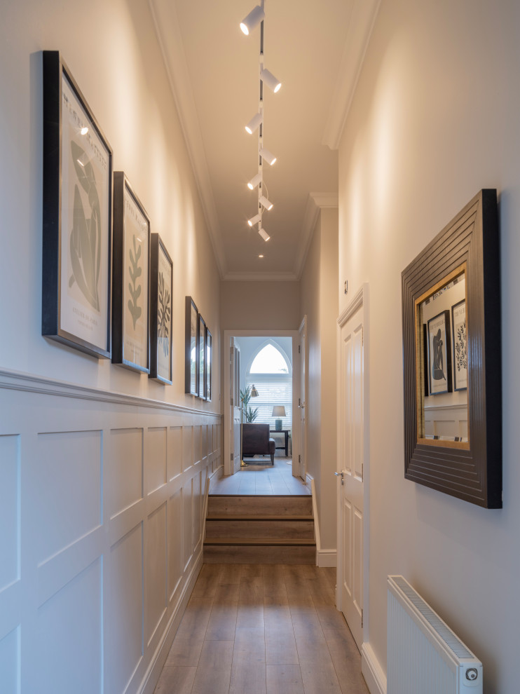 Idée de décoration pour un couloir vintage de taille moyenne avec un mur gris, sol en stratifié et un sol marron.