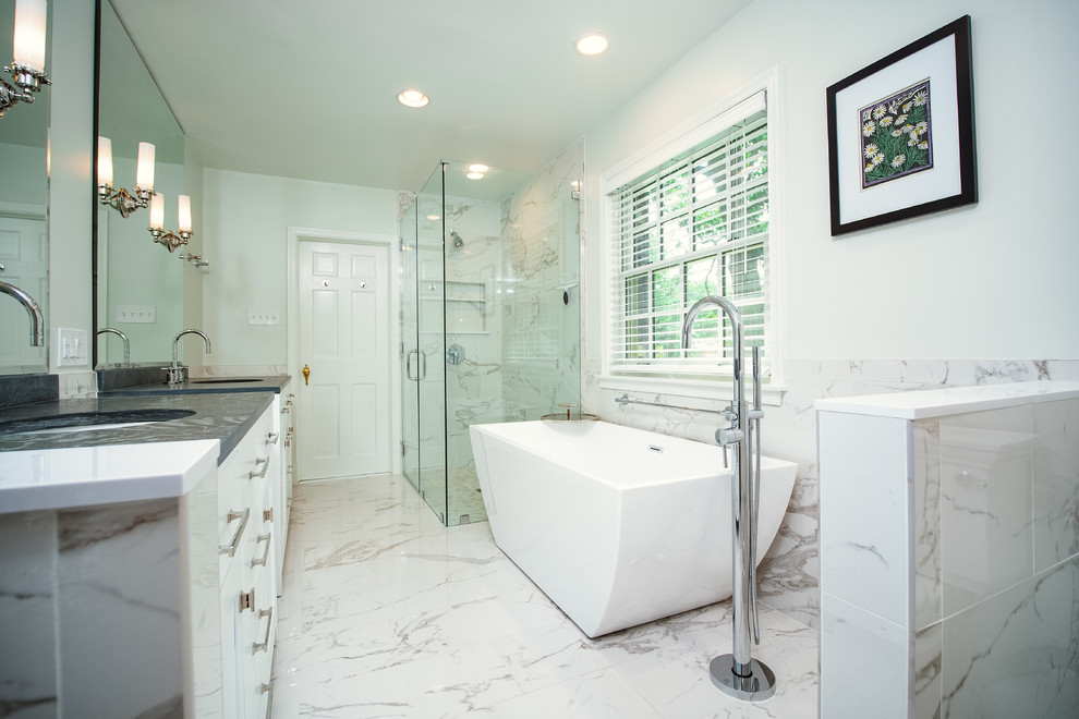 This is an example of a large contemporary master bathroom in Baltimore with white cabinets, a freestanding tub, a curbless shower, white tile, marble, marble floors, an undermount sink, quartzite benchtops, white floor, a hinged shower door, grey benchtops, white walls and recessed-panel cabinets.