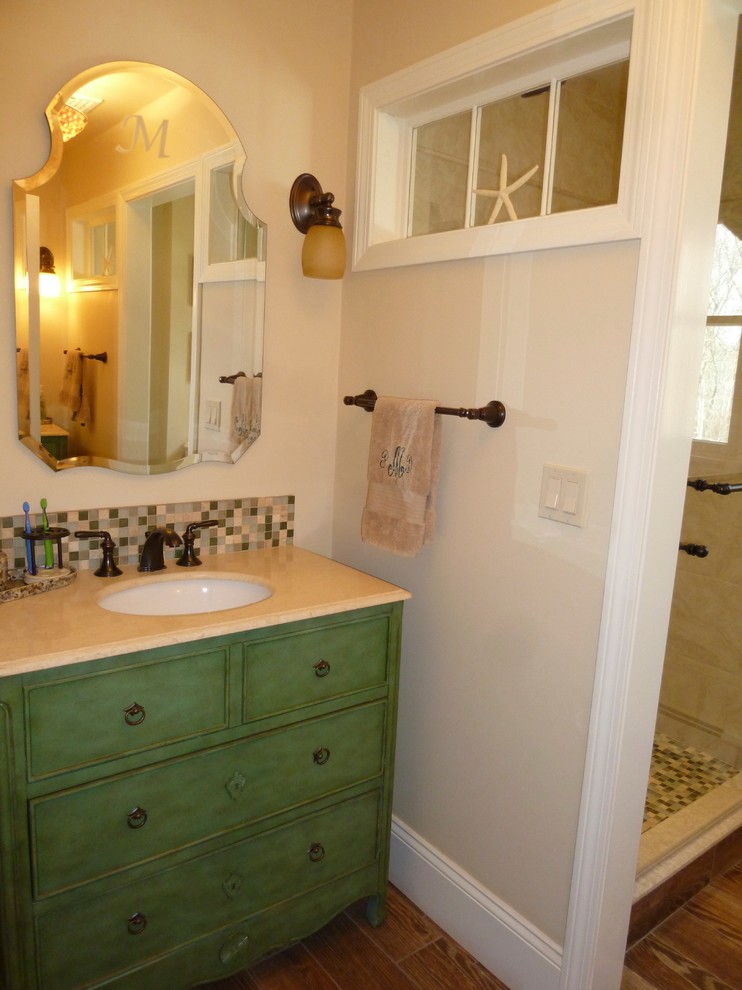 Example of a mid-sized beach style kids' green tile ceramic tile alcove shower design in Boston with an undermount sink, furniture-like cabinets, green cabinets, limestone countertops, a one-piece toilet and beige walls