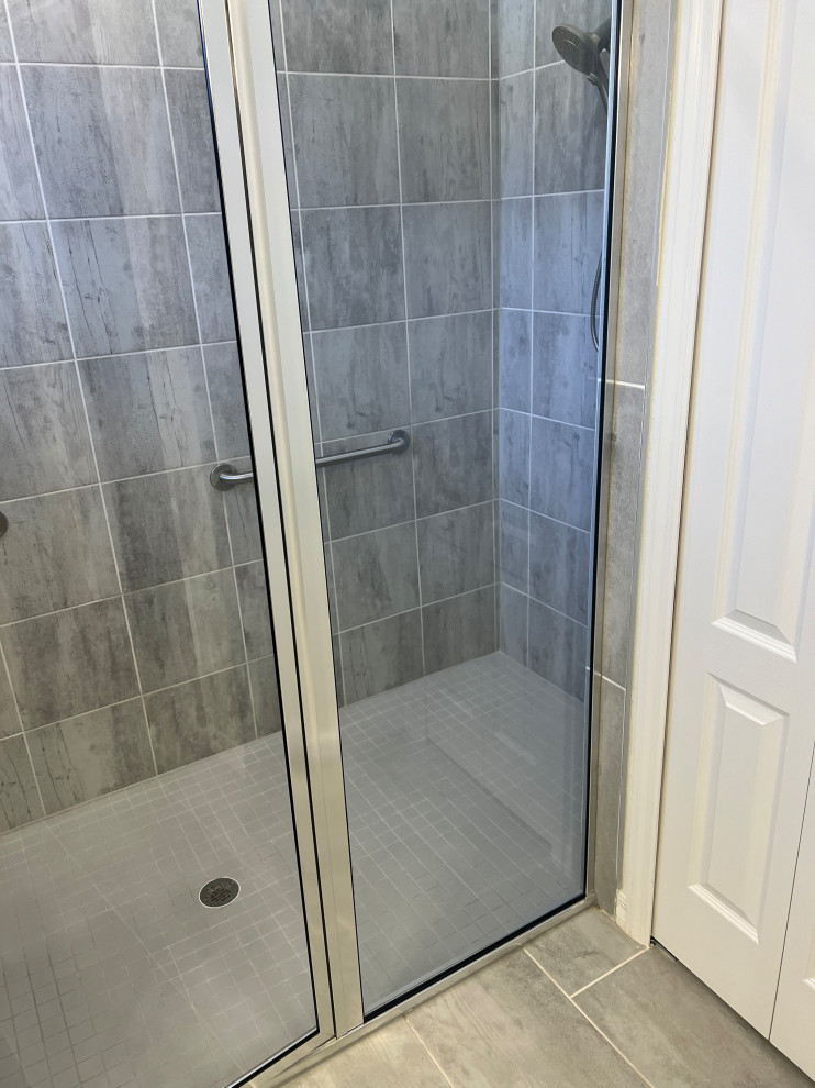 Idéer för mellanstora vintage flerfärgat en-suite badrum, med luckor med upphöjd panel, vita skåp, en dusch i en alkov, vit kakel, keramikplattor, beige väggar, ett nedsänkt handfat, granitbänkskiva, grått golv och dusch med gångjärnsdörr