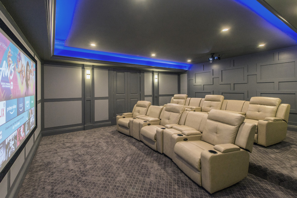 This is an example of a traditional enclosed home theatre in New York with grey walls, carpet, a projector screen and grey floor.