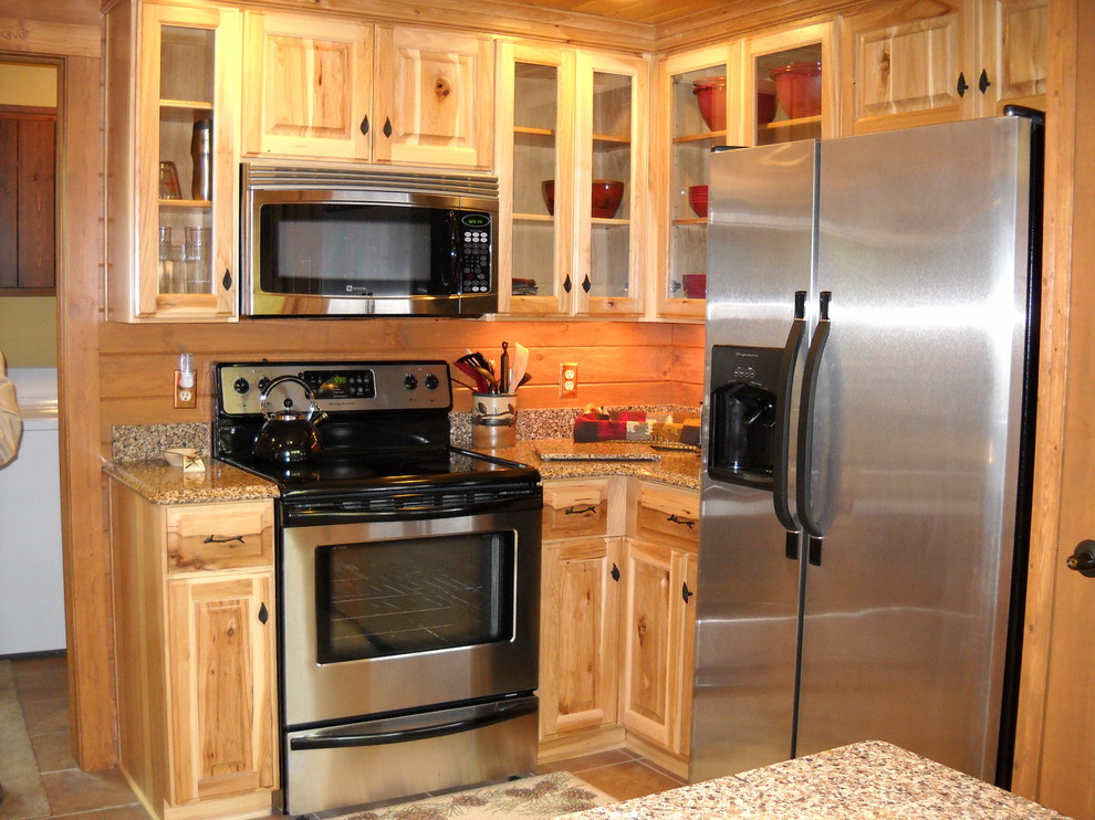 Mid-sized mountain style u-shaped medium tone wood floor and brown floor open concept kitchen photo with glass-front cabinets, light wood cabinets, granite countertops, brown backsplash, wood backsplash, stainless steel appliances and an island
