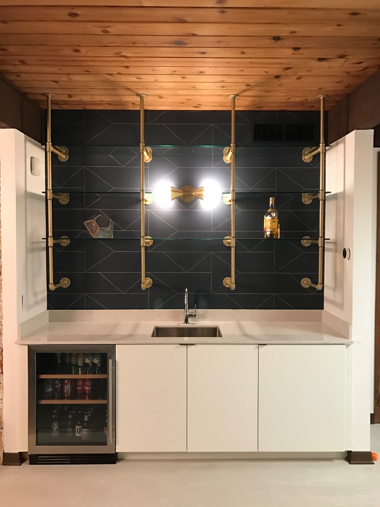 Design ideas for a small midcentury single-wall wet bar in Austin with an undermount sink, flat-panel cabinets, white cabinets, quartz benchtops, grey splashback, porcelain floors and grey floor.