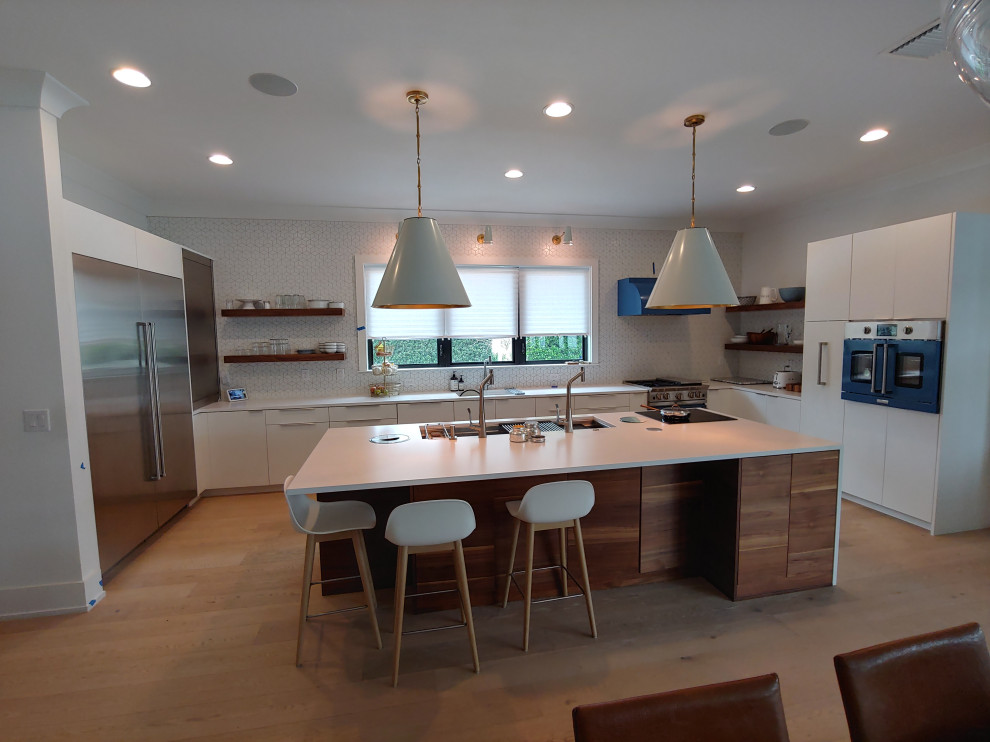 Inspiration for a large midcentury u-shaped eat-in kitchen in Tampa with an undermount sink, flat-panel cabinets, white cabinets, quartz benchtops, white splashback, ceramic splashback, coloured appliances, light hardwood floors, with island, brown floor and white benchtop.