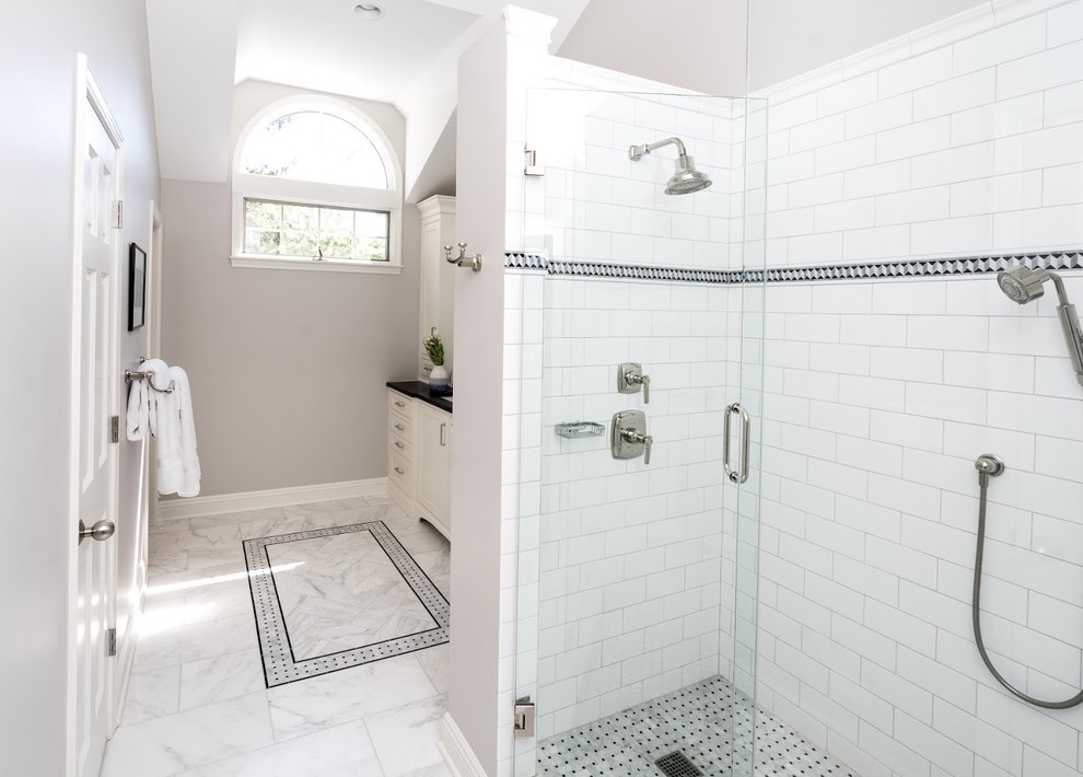 Inspiration for a mid-sized contemporary master bathroom in Chicago with furniture-like cabinets, white cabinets, a corner shower, a two-piece toilet, white tile, ceramic tile, blue walls, marble floors, an undermount sink, tile benchtops, grey floor, a hinged shower door and black benchtops.