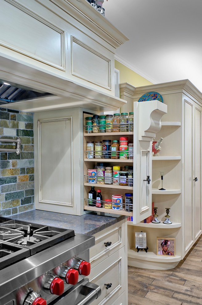 Example of a large mountain style medium tone wood floor kitchen design in Chicago with beaded inset cabinets, distressed cabinets, stone tile backsplash, stainless steel appliances and gray countertops