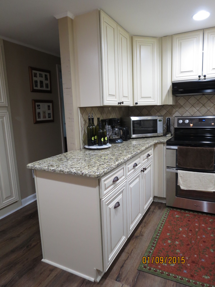 Eat-in kitchen - mid-sized u-shaped eat-in kitchen idea in DC Metro with a double-bowl sink, raised-panel cabinets, white cabinets, granite countertops, beige backsplash, porcelain backsplash and stainless steel appliances