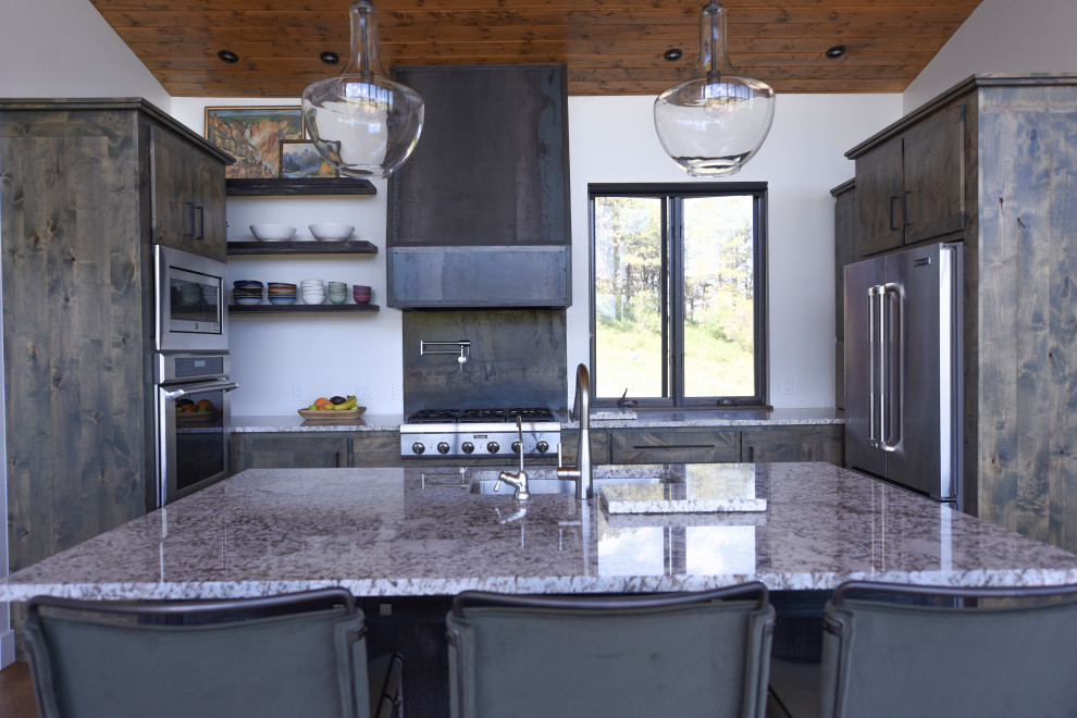 Example of a mountain style kitchen design with stainless steel appliances
