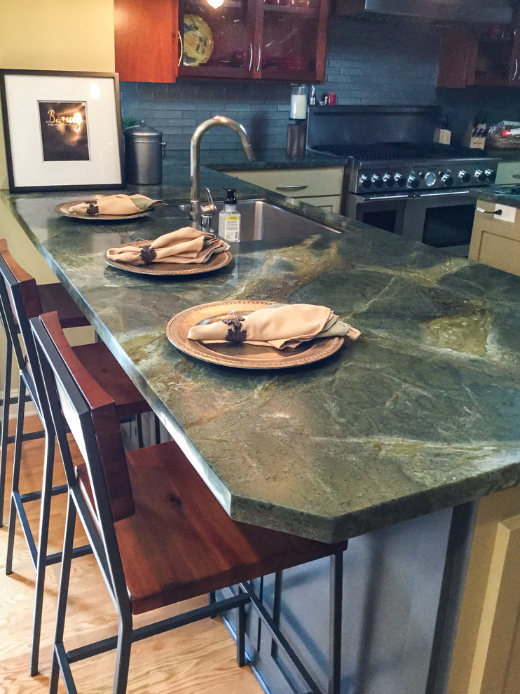 Inspiration for a mid-sized transitional u-shaped medium tone wood floor kitchen remodel with an undermount sink, shaker cabinets, medium tone wood cabinets, granite countertops, blue backsplash, glass tile backsplash, stainless steel appliances and an island