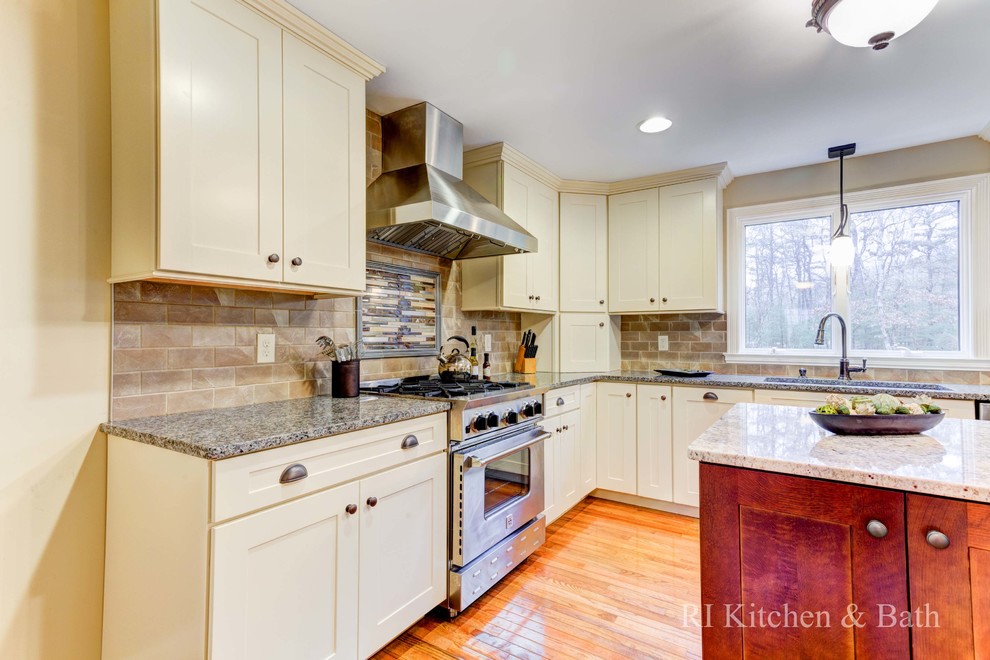 Large transitional u-shaped light wood floor eat-in kitchen photo in Providence with an undermount sink, shaker cabinets, beige cabinets, granite countertops, brown backsplash, porcelain backsplash, stainless steel appliances and an island