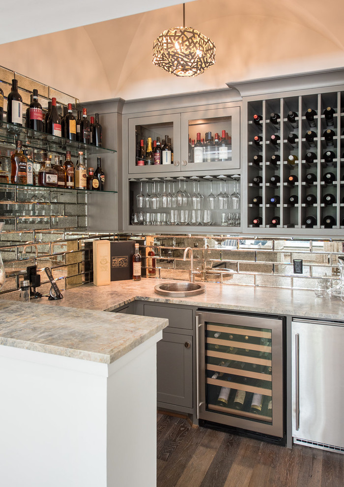 Photo of a mid-sized beach style u-shaped wet bar in Houston with a drop-in sink, recessed-panel cabinets, grey cabinets, granite benchtops, mirror splashback, medium hardwood floors, brown floor and grey benchtop.