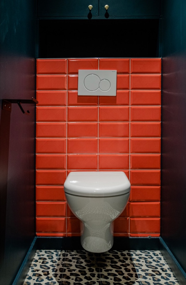 Design ideas for a small cloakroom in Lyon with beaded cabinets, red tiles, blue walls, a built in vanity unit, a wall mounted toilet, metro tiles, cement flooring and multi-coloured floors.