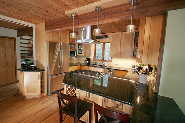 Inspiration for a small transitional l-shaped porcelain tile eat-in kitchen remodel with shaker cabinets, light wood cabinets, granite countertops, beige backsplash, glass tile backsplash, stainless steel appliances and a peninsula
