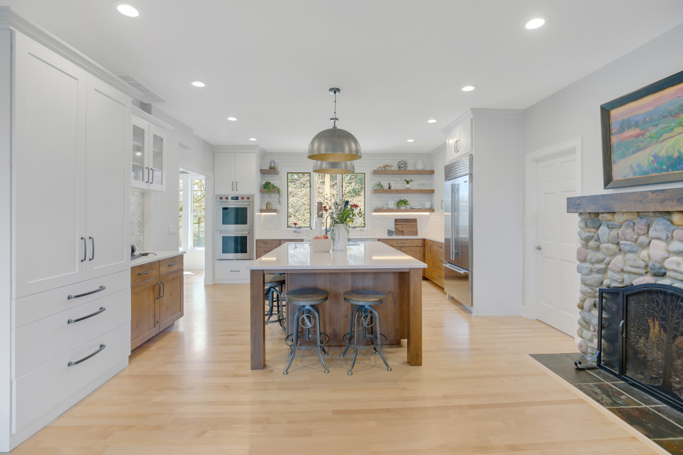 Photo of a large country eat-in kitchen in Portland with shaker cabinets, medium wood cabinets, quartz benchtops, light hardwood floors, with island, brown floor and white benchtop.