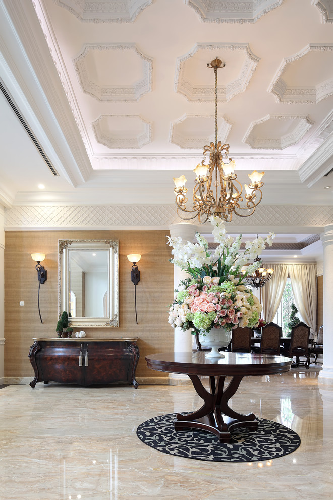 Photo of a traditional foyer in Other with beige walls and marble floors.