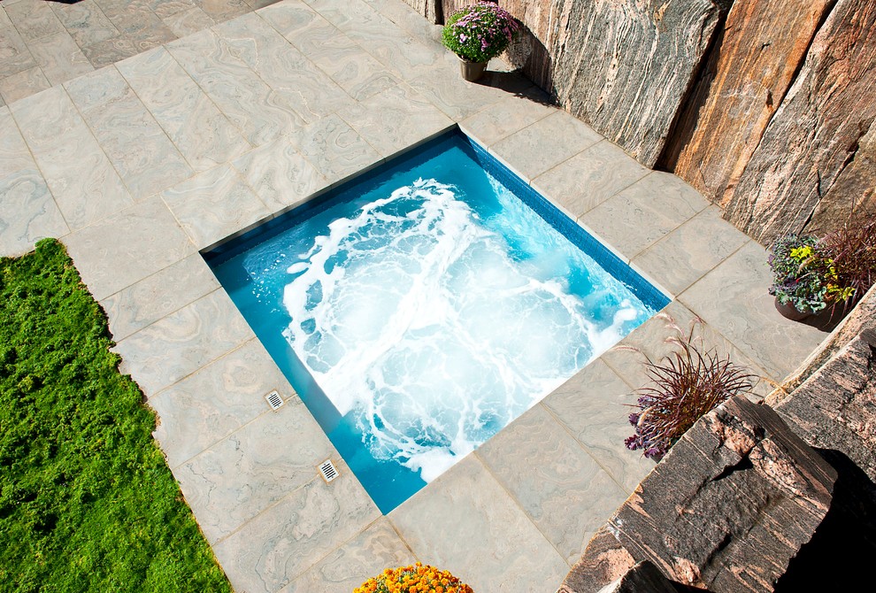 This is an example of a small modern backyard rectangular pool in Toronto with a hot tub.