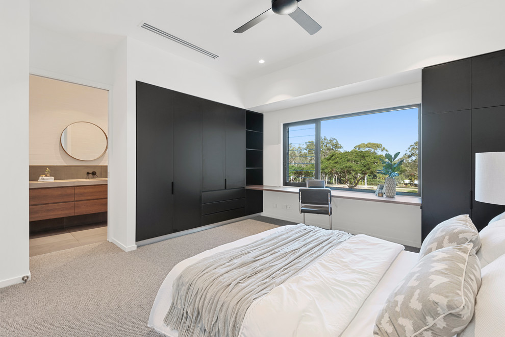 Photo of a large contemporary bedroom in Brisbane with carpet and beige floor.