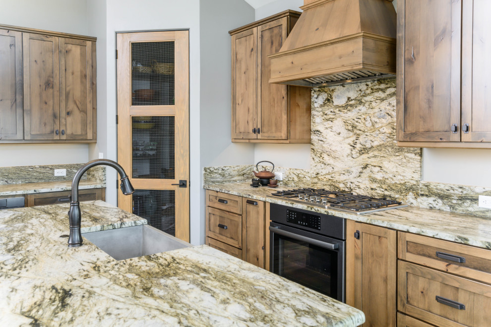 Example of a transitional eat-in kitchen design with an undermount sink, shaker cabinets, medium tone wood cabinets, multicolored backsplash, stone slab backsplash, stainless steel appliances, an island and multicolored countertops