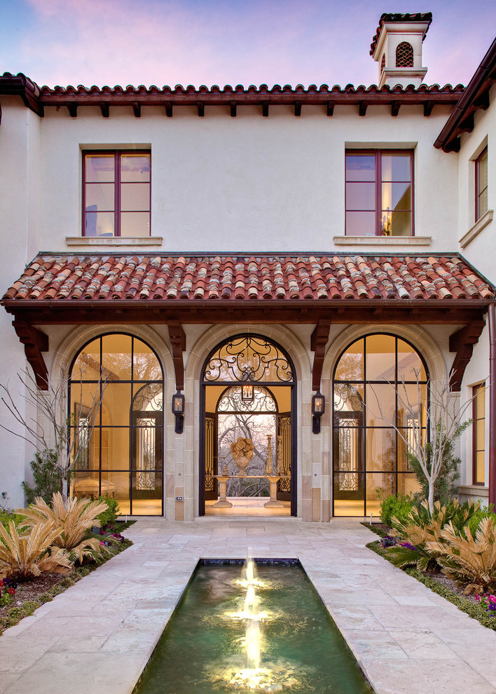 Inspiration for a mediterranean two-storey exterior in Dallas with a tile roof.