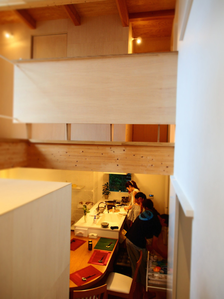 東京都下にあるシャビーシック調のおしゃれなキッチン (一体型シンク、フラットパネル扉のキャビネット、白いキャビネット、人工大理石カウンター、白いキッチンパネル、セラミックタイルのキッチンパネル、シルバーの調理設備、無垢フローリング、茶色い床、白いキッチンカウンター) の写真