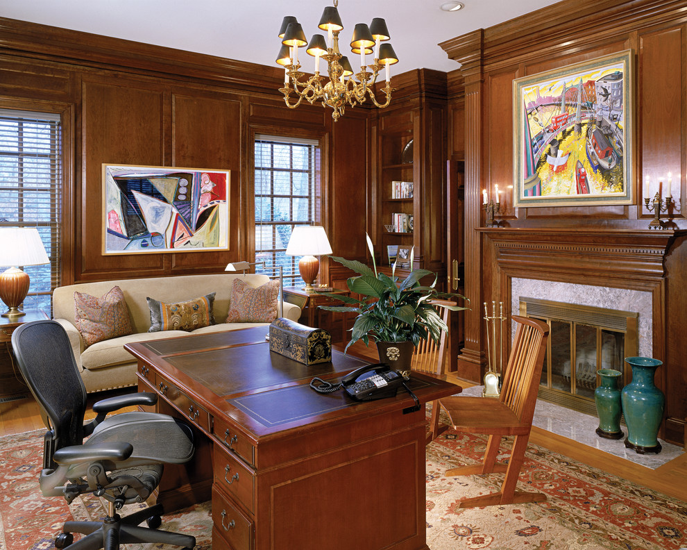 Large traditional study room in DC Metro with brown walls, medium hardwood floors, a standard fireplace, a stone fireplace surround and a freestanding desk.
