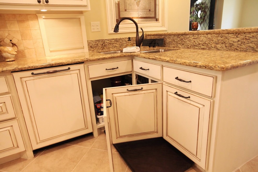 Photo of a traditional kitchen in Houston with an undermount sink, raised-panel cabinets, white cabinets, panelled appliances, porcelain floors, a peninsula, granite benchtops, beige splashback and stone tile splashback.