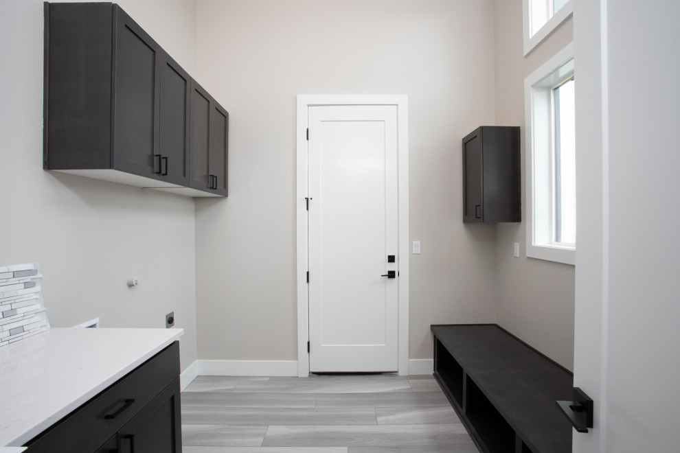 Design ideas for a modern utility room in Portland with black cabinets, quartz benchtops, grey splashback, mosaic tile splashback, grey walls and white benchtop.