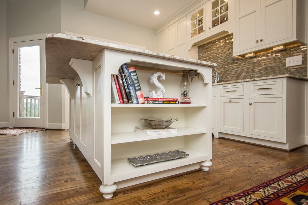 Eat-in kitchen - huge transitional l-shaped medium tone wood floor eat-in kitchen idea in Birmingham with an undermount sink, recessed-panel cabinets, white cabinets, granite countertops, multicolored backsplash, glass tile backsplash, stainless steel appliances and an island