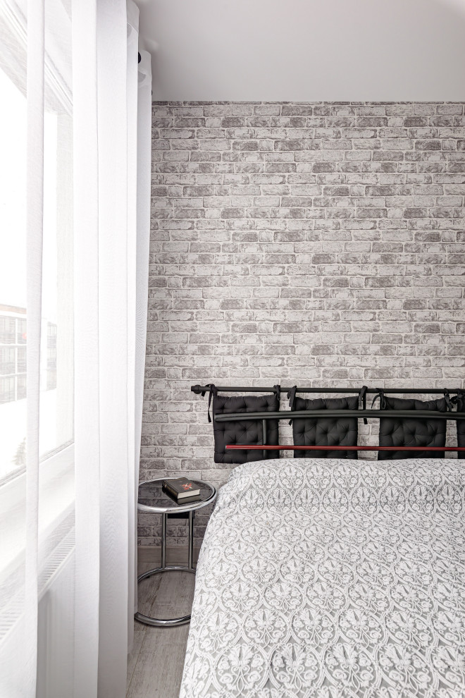 Пример оригинального дизайна: хозяйская, серо-белая спальня в современном стиле с серыми стенами, полом из ламината, серым полом и обоями на стенах