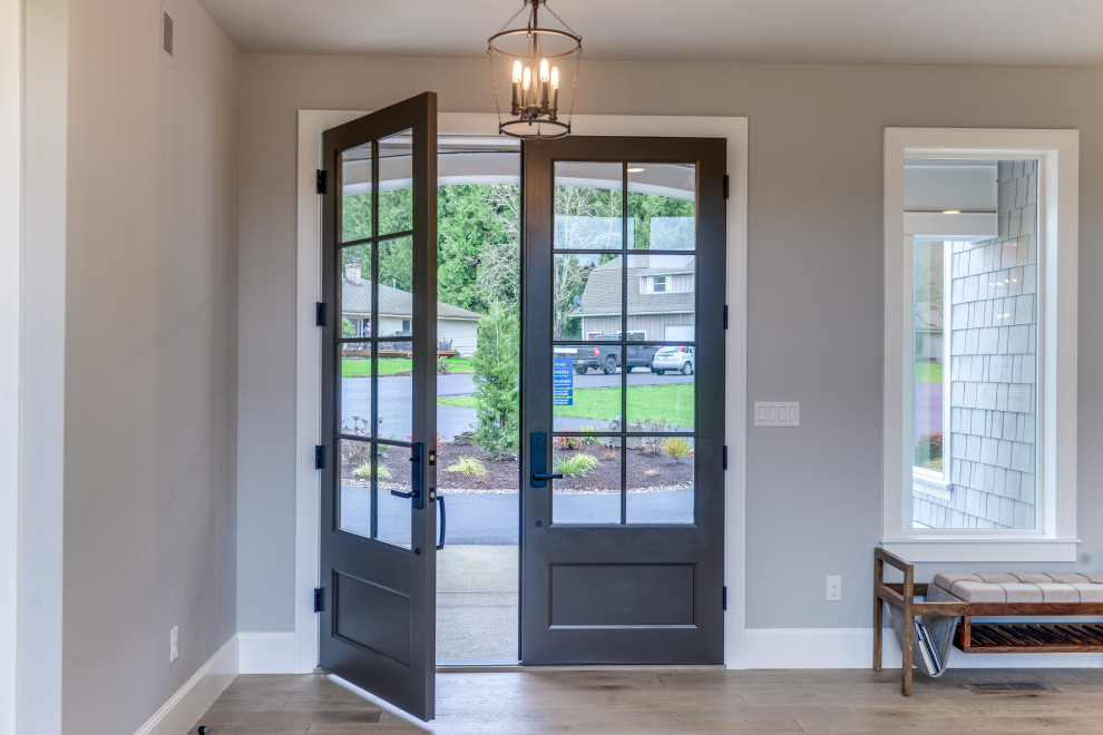 This is an example of a transitional entryway in Portland with grey walls, light hardwood floors, a double front door, a black front door and grey floor.