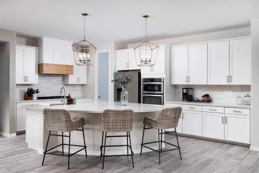 Kitchen - transitional l-shaped gray floor kitchen idea in Phoenix with an undermount sink, shaker cabinets, white cabinets, stainless steel appliances, an island and gray countertops