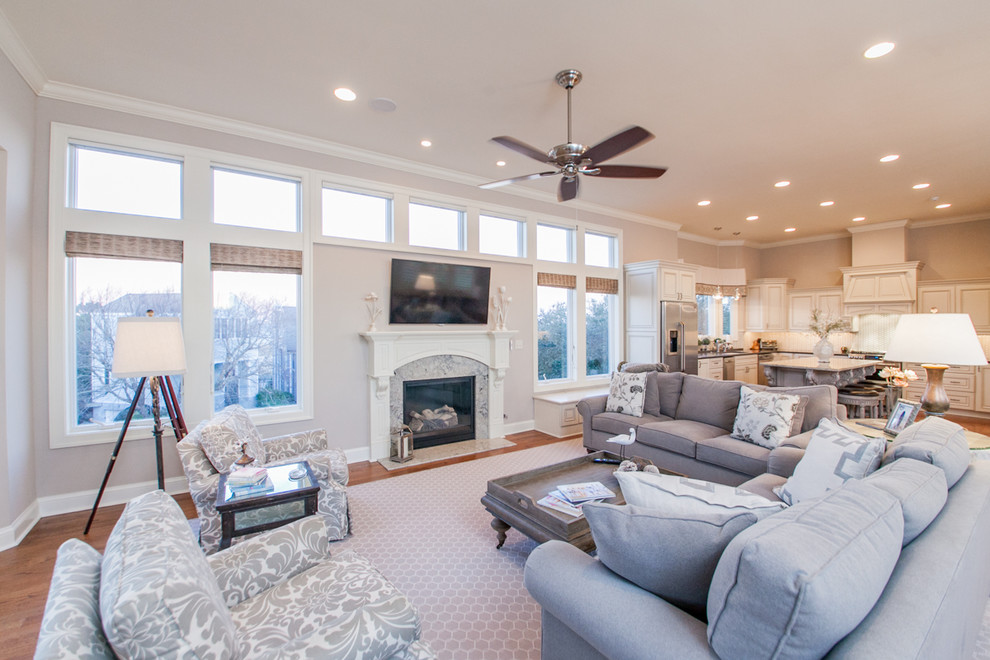 Inspiration for a large traditional open concept family room in Other with beige walls, medium hardwood floors, a standard fireplace, a stone fireplace surround, a wall-mounted tv and brown floor.