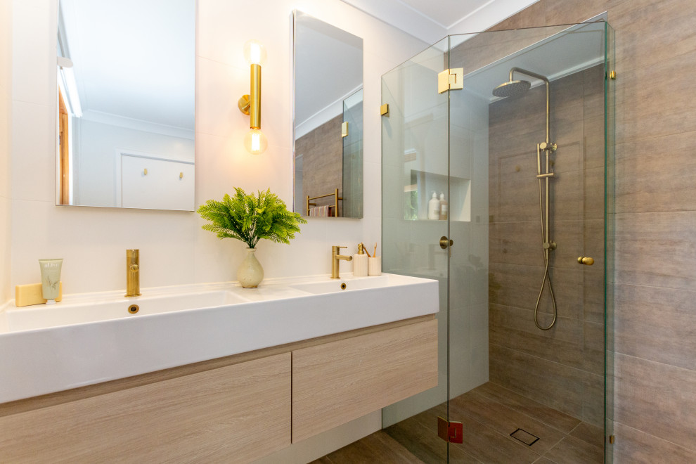 Exempel på ett mellanstort modernt vit vitt badrum med dusch, med släta luckor, skåp i ljust trä, ett fristående badkar, en hörndusch, en toalettstol med separat cisternkåpa, ett integrerad handfat och dusch med gångjärnsdörr