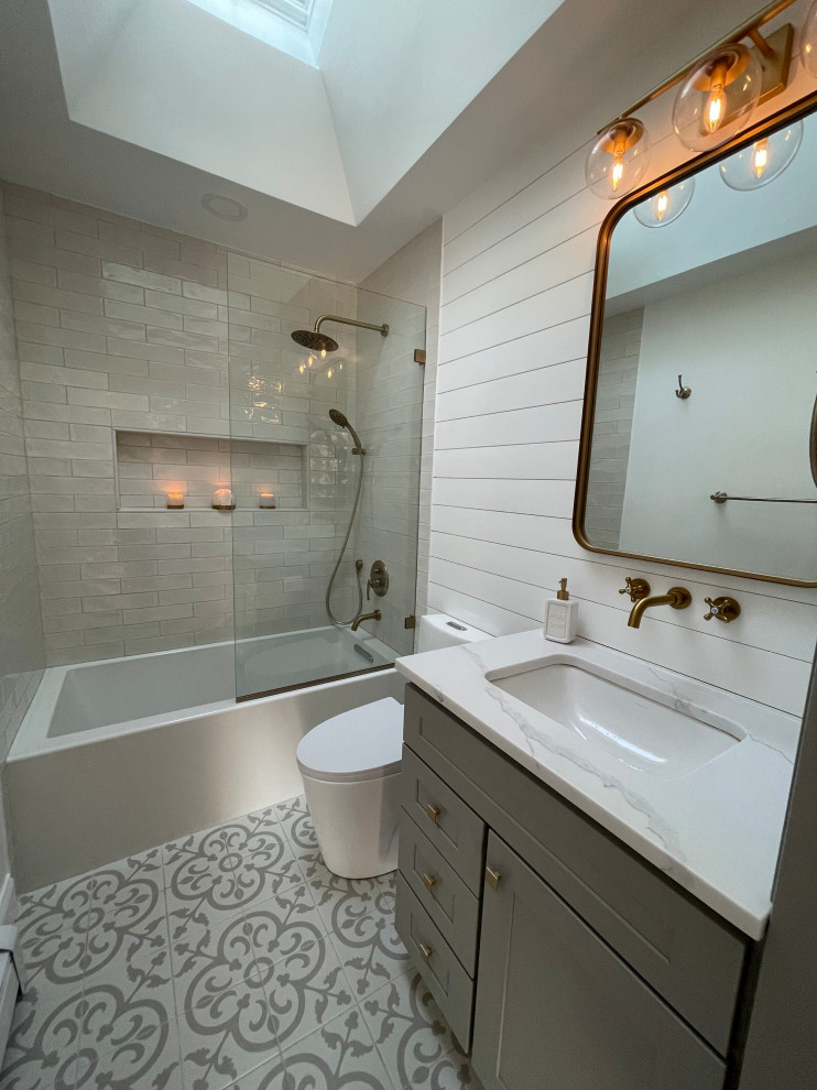 На фото: маленькая главная ванная комната в классическом стиле с фасадами с утопленной филенкой, серыми фасадами, ванной в нише, душем, унитазом-моноблоком, белой плиткой, белыми стенами, полом из керамической плитки, накладной раковиной, столешницей из гранита, разноцветным полом, белой столешницей, нишей, тумбой под одну раковину и напольной тумбой для на участке и в саду с