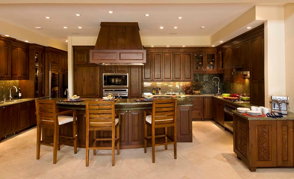 Mid-sized tropical u-shaped open plan kitchen in Hawaii with an undermount sink, raised-panel cabinets, medium wood cabinets, granite benchtops, green splashback, stone slab splashback, panelled appliances, travertine floors, with island, beige floor and green benchtop.